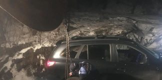 Mașină împotmolită pe un drum forestier, pe marginea unei râpe